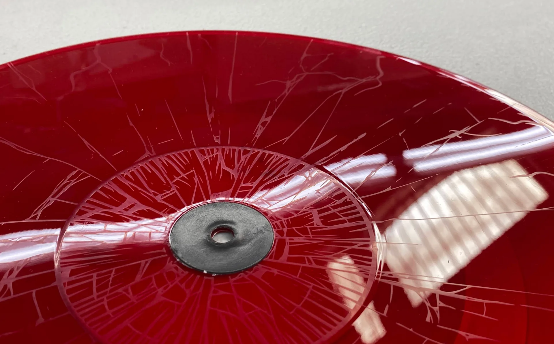 Close-up macro of translucent red vinyl pressing showing label and grooves